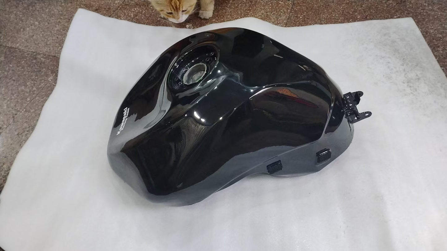 Front three-quarter view of glossy black ZX6R fuel tank on mat, Kawasaki decal visible