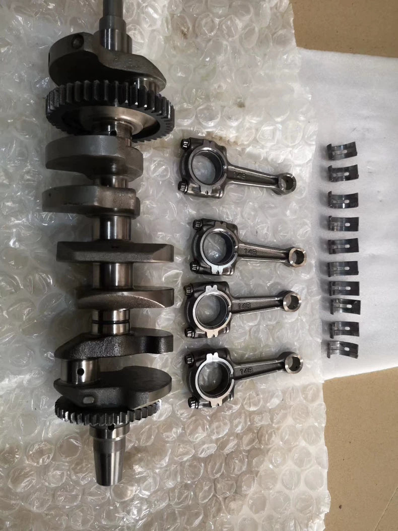Full YZF-R1 crankshaft upright with four 14B connecting rods and bearing shells laid out beside