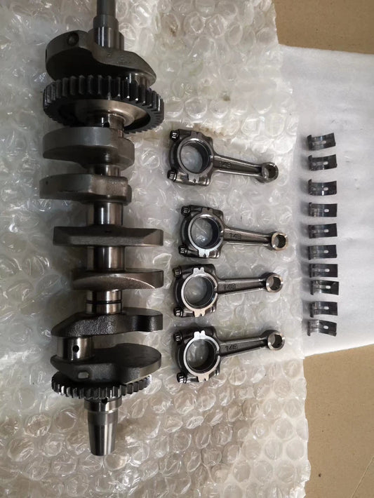 Full YZF-R1 crankshaft upright with four 14B connecting rods and bearing shells laid out beside