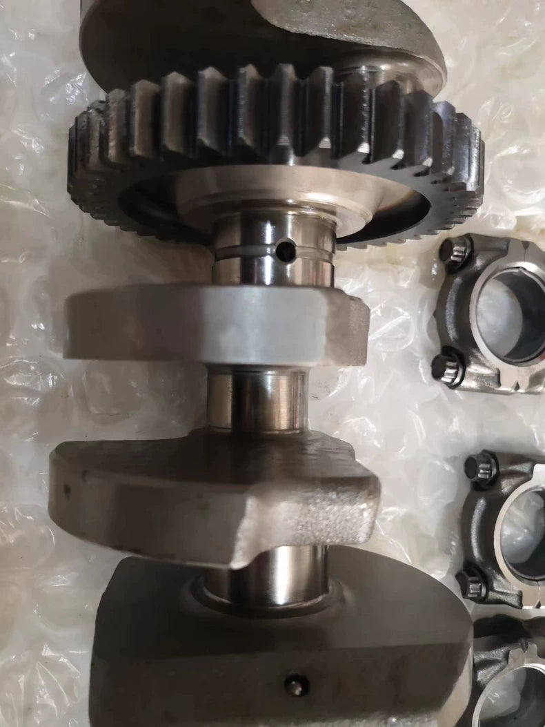 YZF-R1 crankshaft primary drive gear and machined main journals close-up with rod caps beside