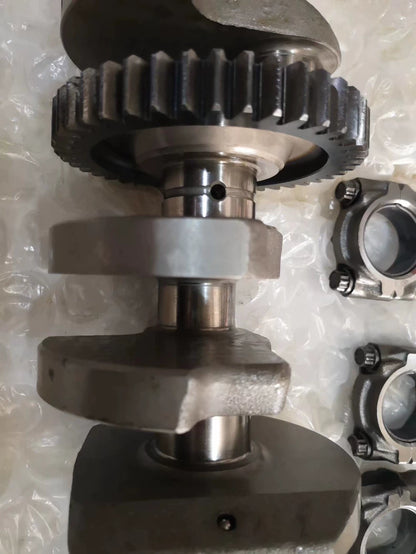 YZF-R1 crankshaft primary drive gear and machined main journals close-up with rod caps beside