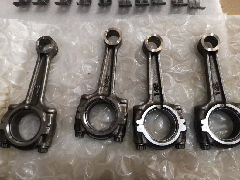 Four YZF-R1 connecting rods marked 14B lined up on bubble wrap, big-end caps and bolts visible