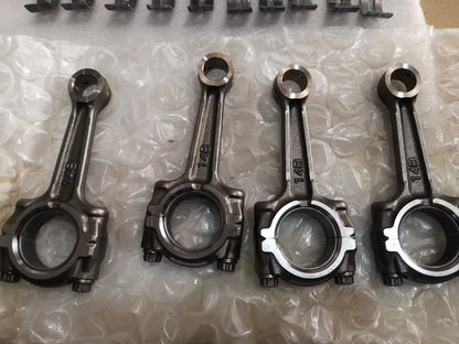 Four YZF-R1 connecting rods marked 14B lined up on bubble wrap, big-end caps and bolts visible