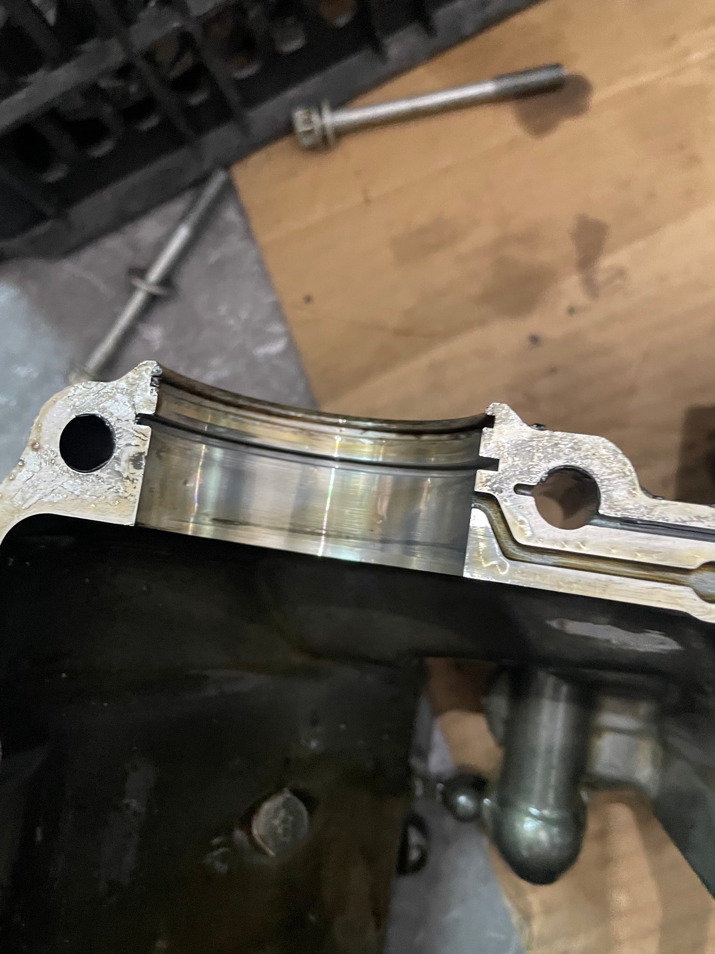 Detail of YZF-R6 crankcase main bearing journal, machined saddle surface and bolt hole, disassembled