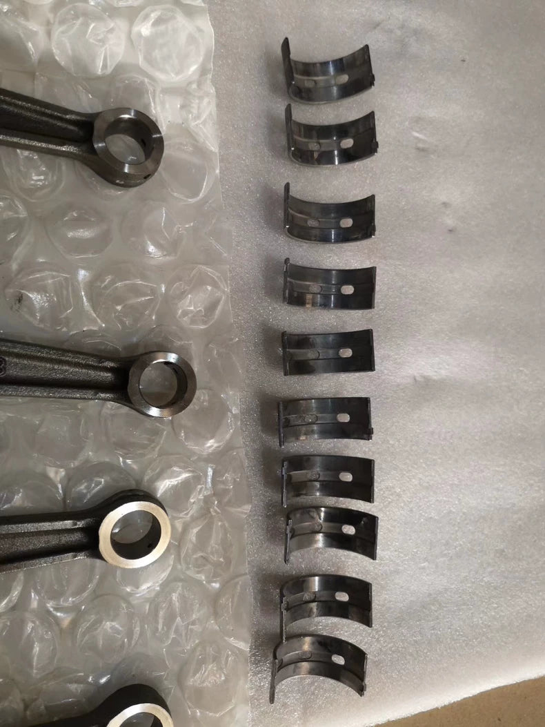 YZF-R1 crankshaft connecting rods and row of main bearing shells laid out on bubble wrap, close view