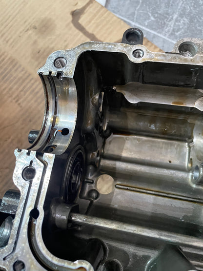 Close-up of YZF-R6 crankcase bearing bore and threaded bolt holes with oil galleries, disassembled
