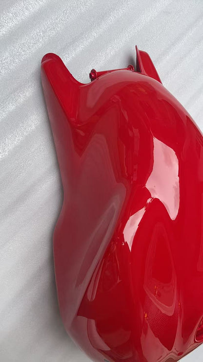 Angled side view of glossy red Ducati Monster 821 fuel tank showing curved contour and front mount