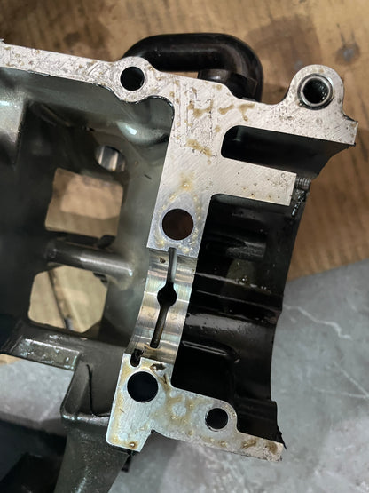 Angled view of YZF-R6 crankcase bearing saddle with bearing shell and locating dowel, gasket surface