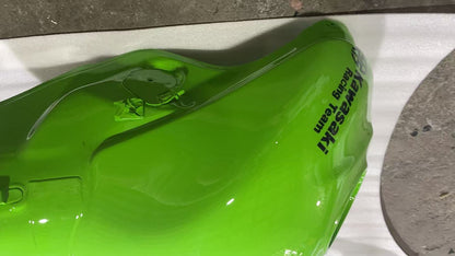 Left side angle of green ZX10R fuel tank showing fuel pump area, breather fitting and Kawasaki Racing Team decal