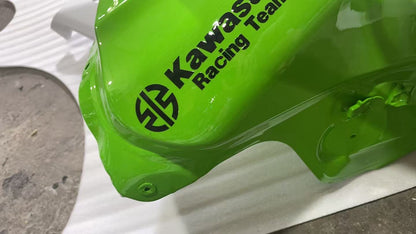 Close-up of Kawasaki Racing Team logo decal on lime green ZX10R fuel tank, high-gloss paint