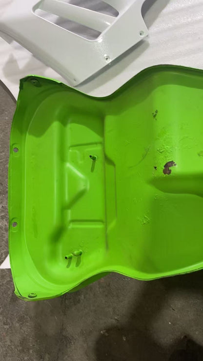 Inside underside of green ZX10R tank tunnel showing ribbed panel, mount holes and small rust patches