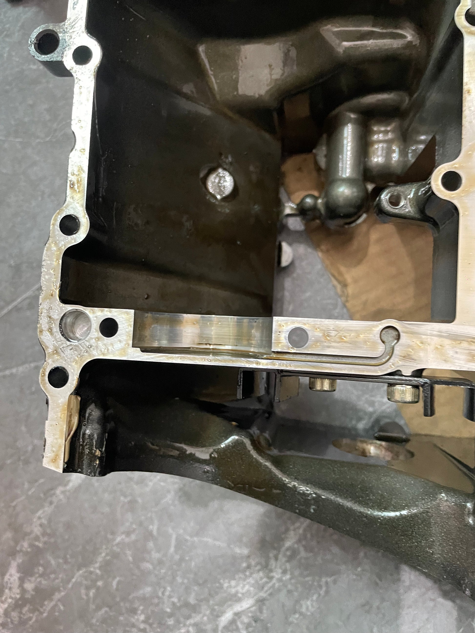 Close-up of YZF-R6 crankcase mating surface with oil passages and main bearing saddle, gasket edge visible