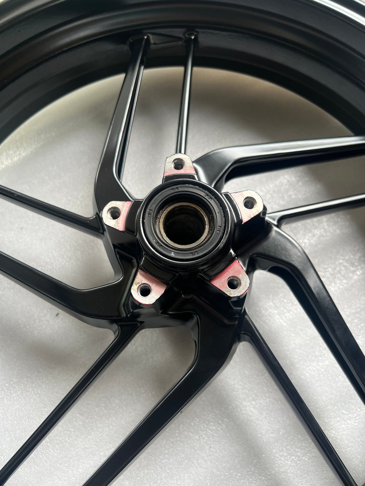 Ducati Monster 821 front wheel, close-up of hub center and axle area, used condition visible