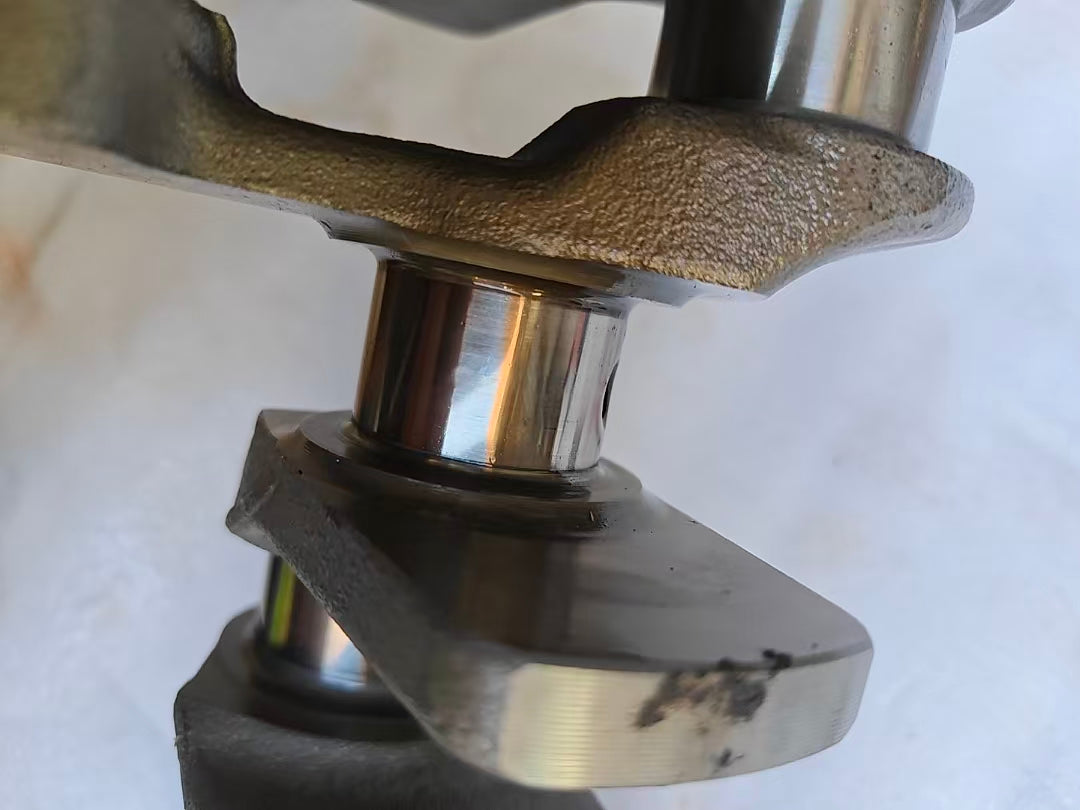 Extreme close-up of one Yamaha MT-09 crankshaft main journal, polished bearing surface with light marks near counterweight