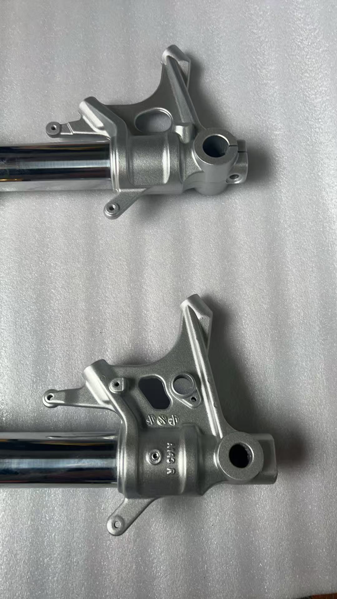 Aprilia RS 660 front fork bottom axle clamps close-up, showing mounting hardware detail