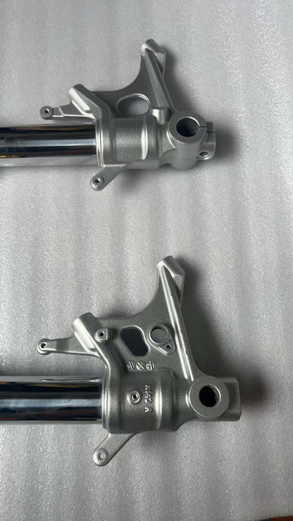Aprilia RS 660 front fork bottom axle clamps close-up, showing mounting hardware detail