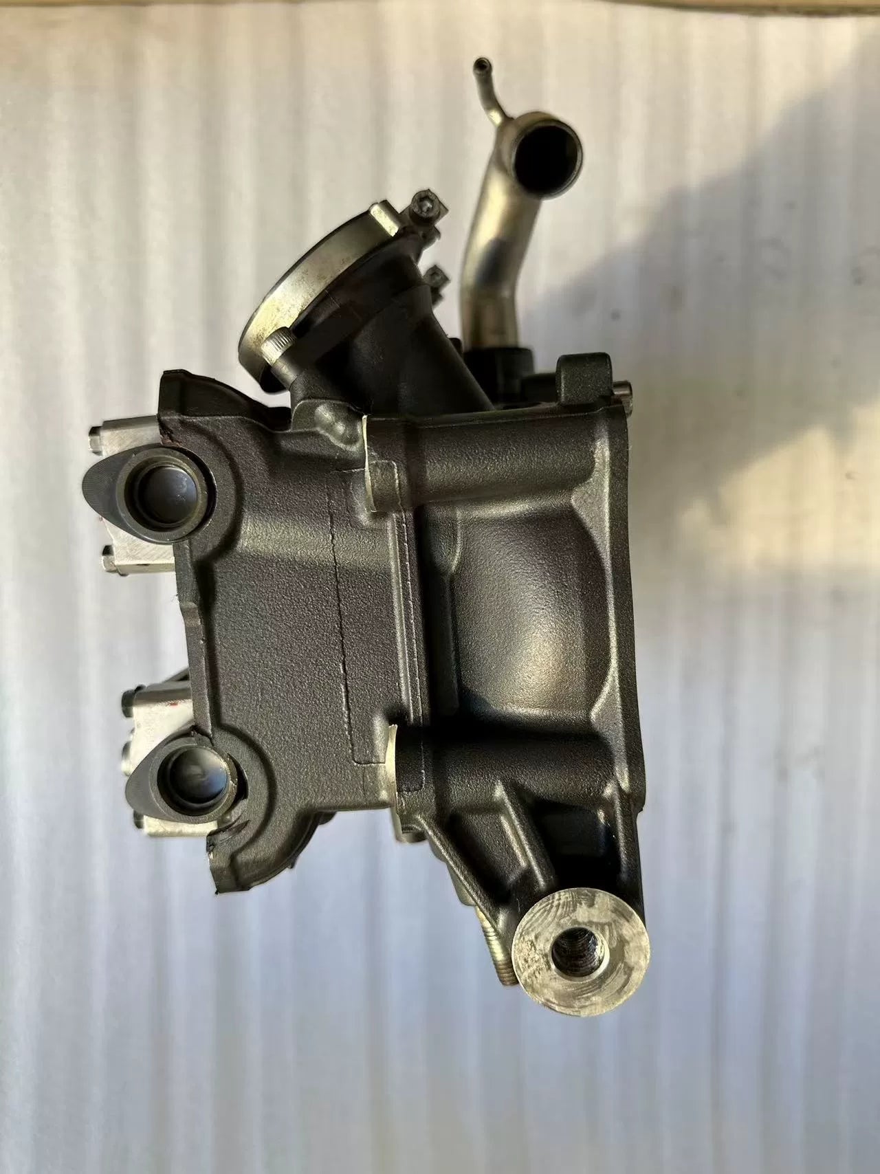 Yamaha YZF-R1 cylinder head end view showing coolant pipe stub and mounting bores, used condition