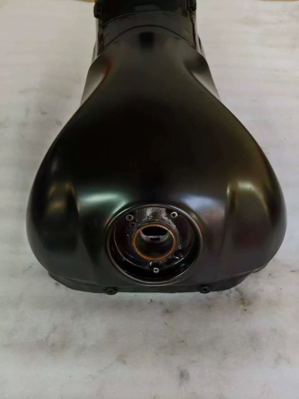 Close-up of fuel pump mounting flange and seal ring on underside of black Kawasaki ZX10R fuel tank
