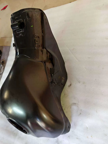 Angled overhead view of black Kawasaki ZX10R fuel tank showing front mounting brackets and light surface scuffs