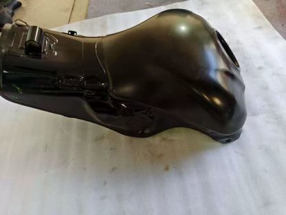 Rear three-quarter side view of black Kawasaki ZX10R fuel tank, glossy paint with minor scratches near base