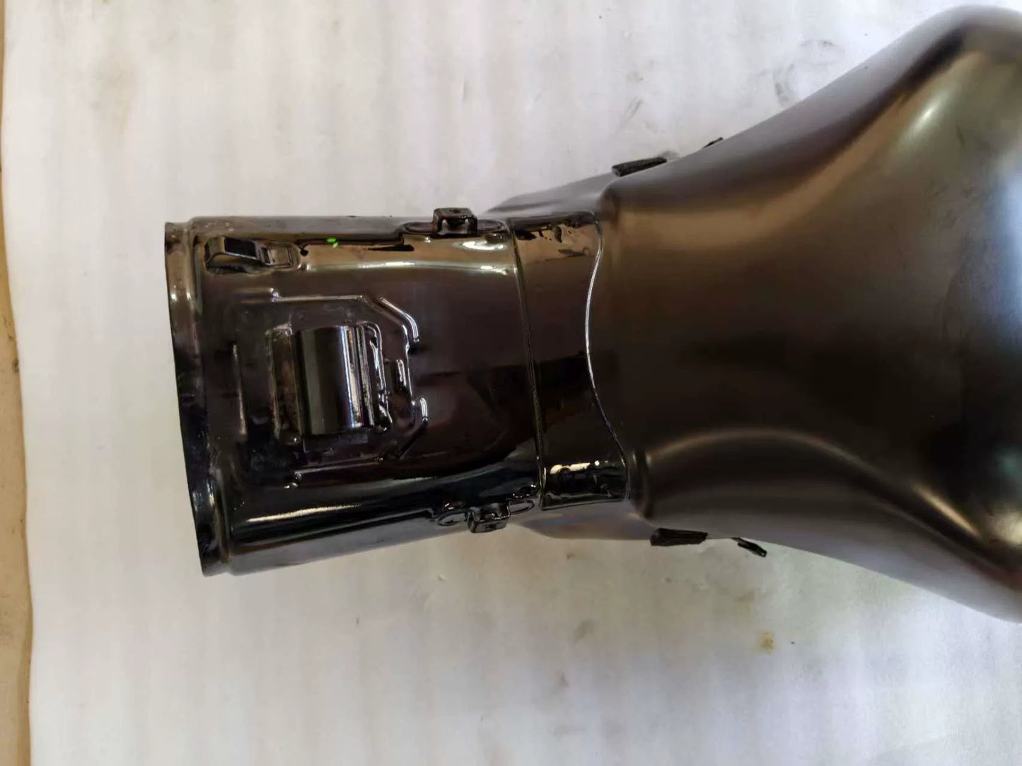 Close-up of front neck section and mounting tabs on black Kawasaki ZX10R fuel tank, worn rubber pads visible