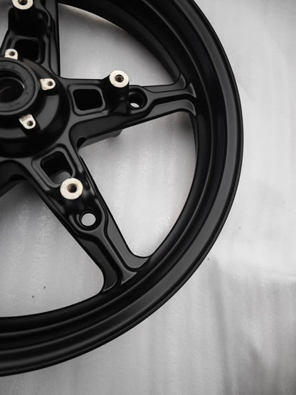 Angled view of matte black cast front wheel rim edge and spoke for BMW R NineT