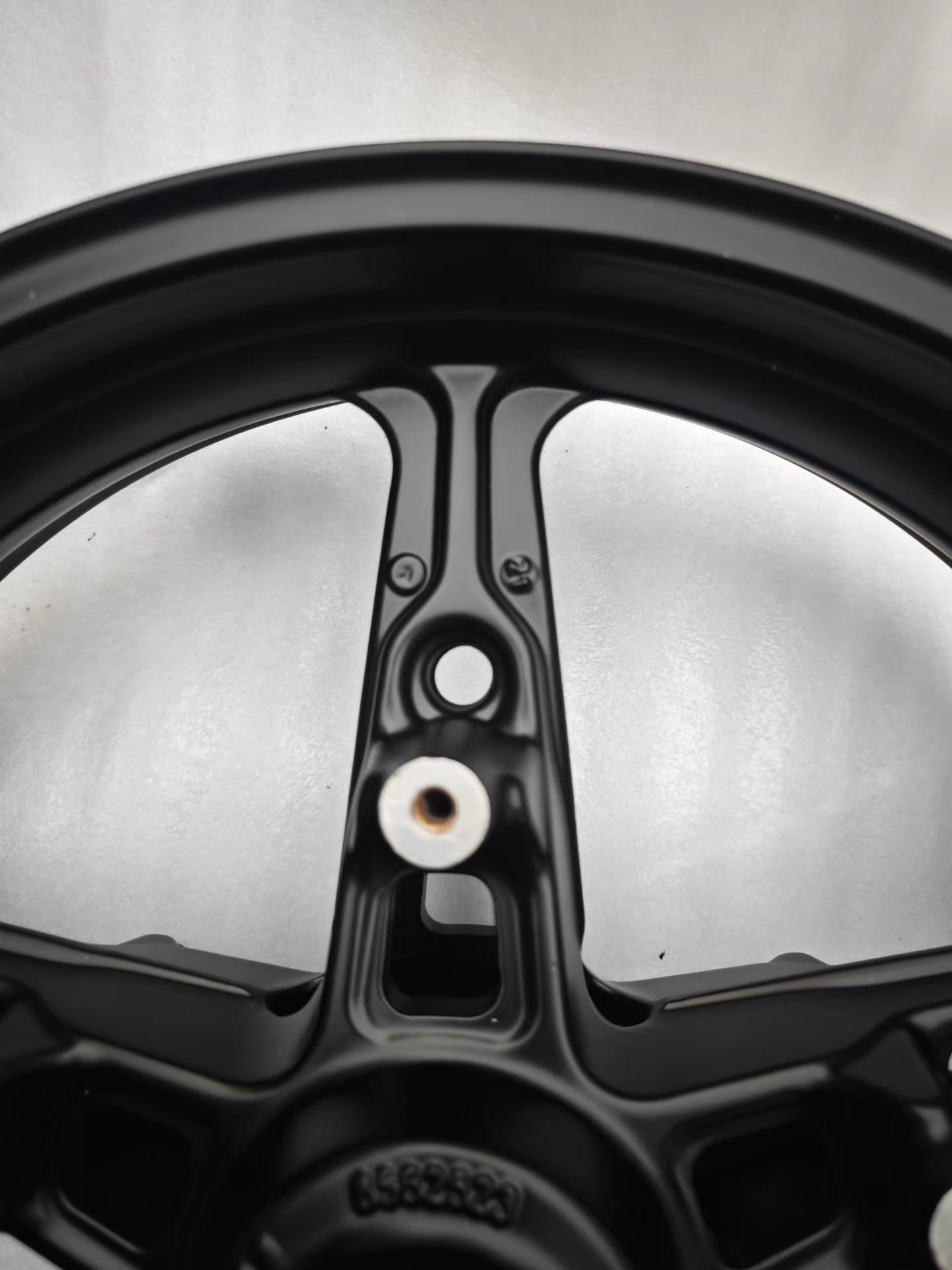Close-up of black cast front rim spoke and inner barrel with valve hole, BMW R NineT