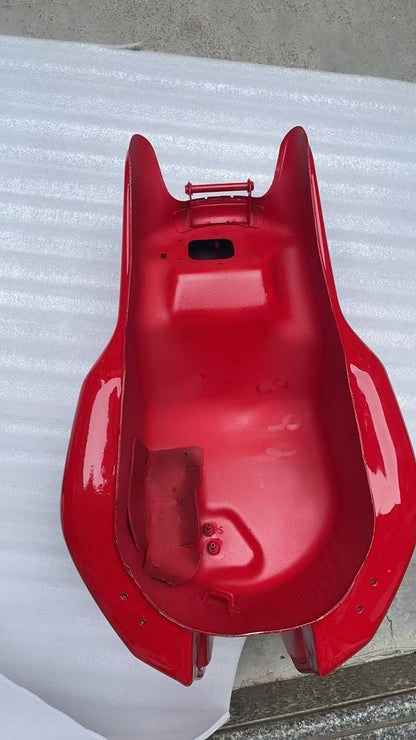 Full underside view of red Ducati Monster 821 fuel tank showing interior cavity, mounts and pump holes