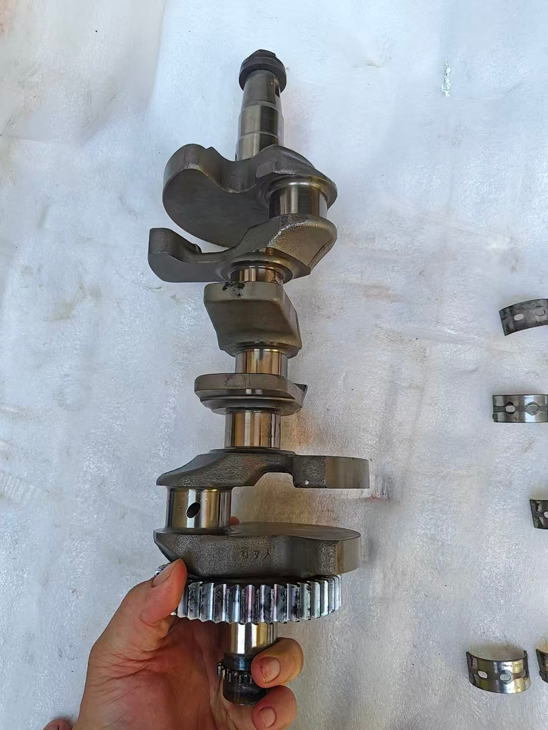 Angled Yamaha MT-09 crankshaft held showing two main journals and counterweights, polished pins with oil hole