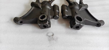 Close-up of two YZF-R6 fork lower brackets, black cast axle clamps and caliper mounts, front detail