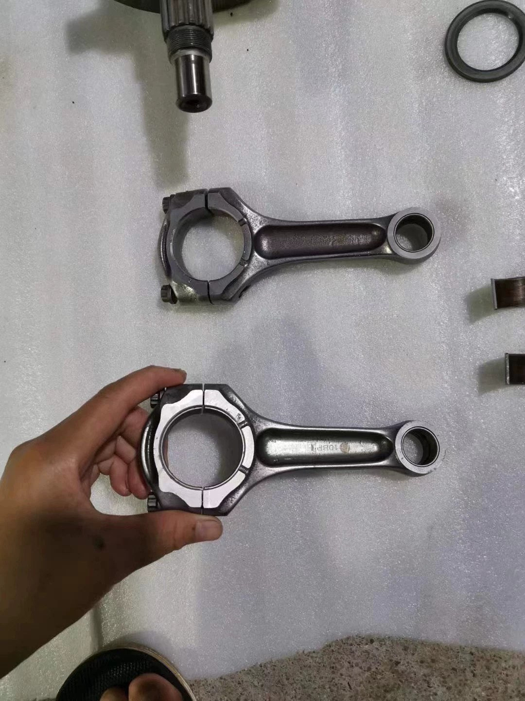 Ducati 848 connecting rods pair close-up showing big end bearings and rod bolts, used condition