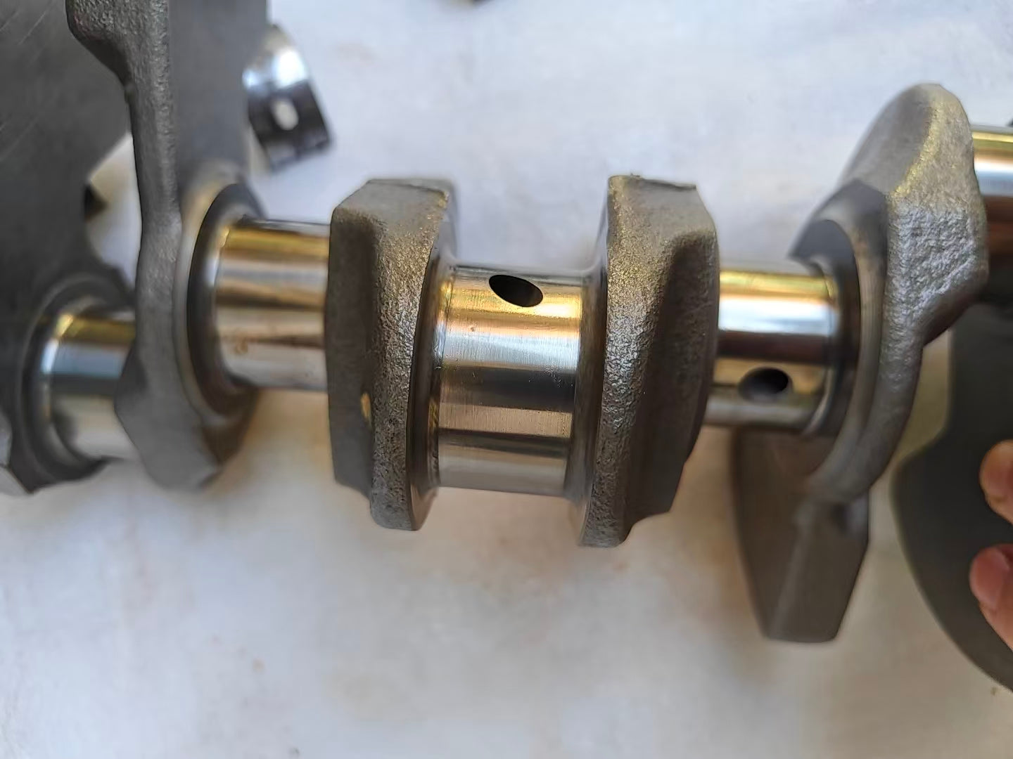 Macro of Yamaha MT-09 crankshaft center main journals, polished surfaces with oil holes and cast counterweights